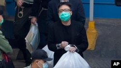 FILE - Tam Tak-chi, salah satu dari 47 aktivis pro-demokrasi Hong Kong, dikawal petugas Lembaga Pemasyarakatan di Hong Kong, 2 Maret 2021. Pengadilan Banding Hong Kong, Kamis, 7 Maret 2024 menguatkan hukuman 40 bulan bagi Tam. (AP/Kin Cheung)
