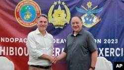 Menteri Pertahanan Australia Richard Marles (kiri) dan Menteri Pertahanan Filipina Gilberto Teodoro Jr. berpose sebelum latihan militer gabungan di pangkalan angkatan laut di San Antonio, Zambales, 25 Agustus 2023. (Foto: Philippine DND Defense Communications Service via AP)