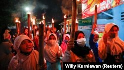 Anak-anak Muslim membawa obor di sekitar lingkungan selama parade untuk merayakan Idul Fitri, menandai akhir bulan suci Ramadan, di tengah pandemi COVID-19 di Jakarta, 12 Mei 2021. (Foto: REUTERS/Willy Kurniawan)