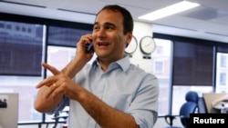 路透社记者贾森•塞普在路透社华盛顿总部接受同事电话祝贺。塞普和路透社因报道缅甸罗兴亚人遭受的暴力迫害而获得普利策奖。（2014年4月14日）