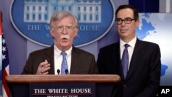 Penasihat keamanan nasional, John Bolton, berbicara sementara Menteri Keuangan, Steven Mnuchin, menyimak dalam sebuah briefing kepada media di Gedung Putih, Senin, 28 Januari 2019, Washington, D.C. (foto: AP Photo/Evan Vucci)