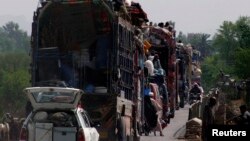 People fleeing the military offensive against the militants in North Waziristan, travel atop a vehicle with their belongings while entering Bannu, located in Pakistan's Khyber-Pakhtunkhwa province, June 20, 2014.