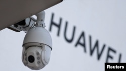 北京一家商场外的华为标志旁安装了一个监控摄像头。（2019年1月29日）