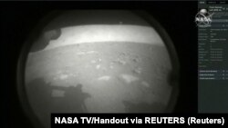 Gambar pertama tiba beberapa saat setelah pesawat roverspacecraft NASA Perseverance Mars berhasil mendarat di Mars, di Jet Propulsion Laboratory NASA di Pasadena, California, AS 18 Februari 2021. (Foto: NASA TV via REUTERS)