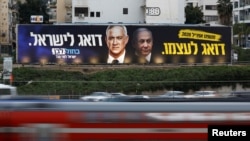 Kendaran melintas di depan poster kampanye pemilu partai Biru dan Putih dengan foto pemimpin partai Benny Gantz and Perdana Menteri Israel Benjamin Netanyahu di Tel Aviv, Israel, 18 Februari 2020. (Foto: Reuters)