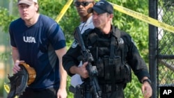 一位共和党球队的成员离开出事现场，旁边是警卫人员（2017年6月14日）