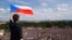 FILE - A man waves the Czech flag as people protest in Prague, Czech Republic, June 23, 2019, calling on Prime Minister Andrej Babis to step down over fraud allegations.
