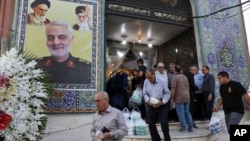 Ljudi napuštaju džamiju u dominantno iračkom južnom kraju Teherana, 30. jula 2019. Na zidu se vidi poster sa likom generala Kasema Sulejmanija, zajedno sa vrhovnim liderom Ali Hameneijem i ajatolom Homeinijem.