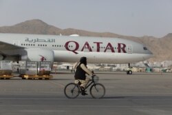 FILE - A Taliban soldier patrols on a bike in front of a Qatar Airways flight at the international airport in Kabul, Afghanistan, September 10, 2021. (West Asia News Agency via Reuters)