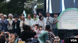 蔡英文竞选总部成立大会，小朋友上台送上募款小猪 (美国之音李逸华拍摄)