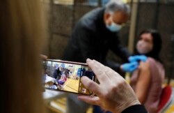 Dokter Anil Mehta tengah menyuntikkan vaksin COVID-19 produksi AstraZeneca kepada seorang tunawisma di akomodasi tunawisma YMCA di Romford, London timur, Rabu, 3 Februari 2021.