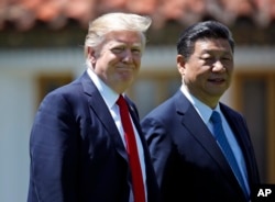 President Donald Trump and Chinese President Xi Jinping walk together after their meetings at Mar-a-Lago, April 7, 2017, in Palm Beach, Fla.