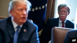 FILE - National security adviser John Bolton listens as President Donald Trump speaks during a cabinet meeting at the White House in Washington, April 9, 2018.
