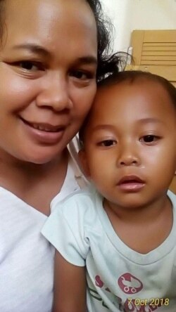 Renata Silalahi, ibu dua anak yang baru saja pulih bergulat dengan COVID-19 yang menjangkiti keluarganya, bersama salah satu putranya. (Foto: pribadi)