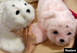 Seorang penghuni panti menyentuh robot anjing laut 'PARO' di panti wreda Shin-tomi di Tokyo, Jepang, 2 Februari 2018.