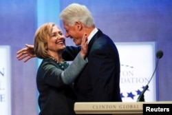 FILE - Former U.S. President Bill Clinton and former U.S. Secretary of State Hillary Clinton embrace during the opening plenary session labeled "Reimagining Impact" at the Clinton Global Initiative 2014 in New York, Sept. 22, 2014.