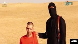 Image taken from video released by Islamic State militants, identified by private terrorism monitor SITE Intelligence Group, purportedly shows masked militant in desert landscape threatening to kill British David Cawthorne Haines, Sep. 2, 2014.