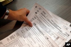 Tax professional and tax preparation firm owner Alicia Utley reaches for hard copies of tax forms at the start of the tax season rush in her offices in Boulder, Colorado, Jan. 14, 2017.