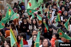 Žene drže zastave Jedinica za zaštitu žena (YPJ) tokom mitinga na kojem se zahteva od novih islamističkih vladara u Damasku da poštuju prava žena i osude vojne kampanje koje podržava Turska u regionima na severu koje predvode Kurdi, u Kamišli, Sirija, 23. decembra, 2024.