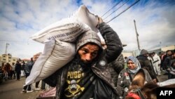 Pengungsi Palestina menerima bantuan makanan di kantor UNRWA di kota Rafah, Jalur Gaza selatan, Minggu (28/1). Sembilan negara donor telah menangguhkan bantuan untuk Gaza, di tengah kelangkaan bantuan kemanusiaan di sana. 