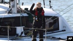 Aktivis iklim Greta Thunberg melambaikan tangannya setibanya di Lisbon dengan kapal katamaran La Vagabonde, Selasa, 3 Desember 2019.