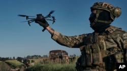 Seorang tentara Ukraine menerbangkan sebuah drone di garis depan dekat Bakhmut, Ukraine, Minggu, 20 Agustus 2023. (Foto: Libkos/AP Photo)
