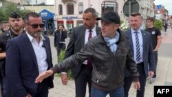 Francuski predsednik Emanuel Makron rukuje e sa ljudima 29. juna 2024. na ulici u Le Tuke Pari Plažu, u severnoj Francuskoj, na fotografii napraljenoj od video snimka.