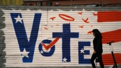 Wata mace tana wucewa gaban alamar zabe a Los Angeles, California.