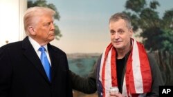 President Donald Trump, accompanied by Marc Fogel, speaks in the Diplomatic Reception Room at the White House, Feb. 11, 2025, in Washington.