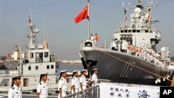 中国海军官兵准备登上青岛号导弹驱逐舰（右）去参加中美海军联合演习（2013年8月20日）