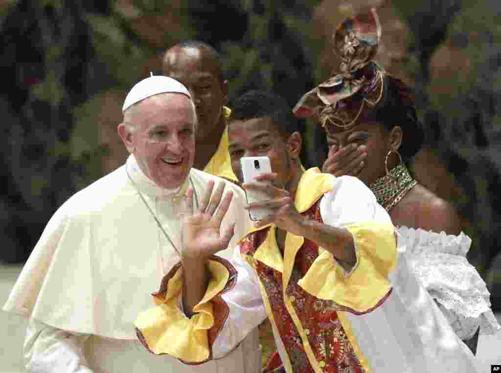 A pilgrim takes a selfie with Pope Francis before the start of the weekly general audience in the Paul VI Hall at the Vatican.