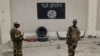 FILE - Soldiers stand at a checkpoint in front of a Boko Haram flag the Nigerian city of Damasak, Nigeria, March 18, 2015. In Senegal, 29 suspects are awaiting a ruling on terrorism-related charges. Most of the suspects are believed to have fought for Boko Haram in Nigeria, while others fought for jihadists in Libya and Mali.