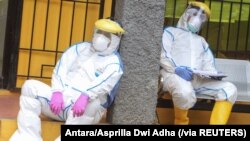 Petugas kesehatan beristirahat saat mereka menyelesaikan tes swab untuk virus korona (COVID-19) di Depok, Indonesia, 8 April 2020. (Foto: Antara/Asprilla Dwi Adha via Reuters)