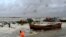 A man pulls a fishing boat to a sea shore as a preventive measure during rainfall in Kuakata on May 26, 2024, ahead of cyclone Remal's landfall in Bangladesh.