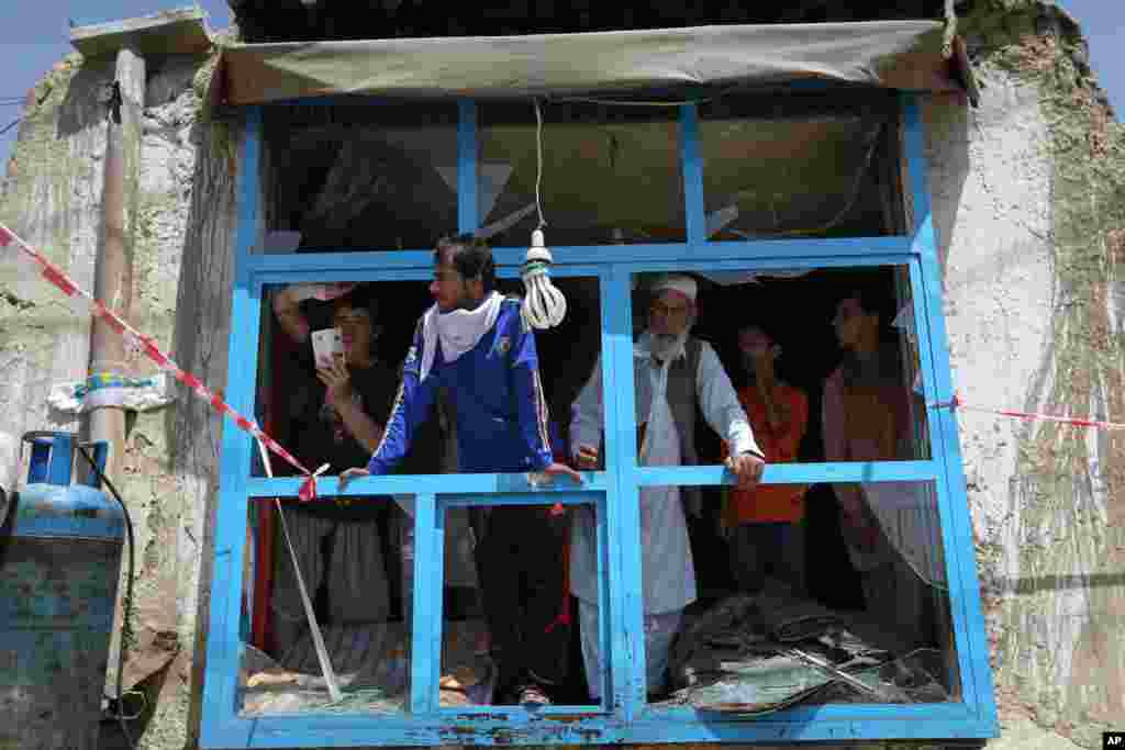 People inspect a shop damaged in a suicide attack, Kabul, May 4, 2015. 