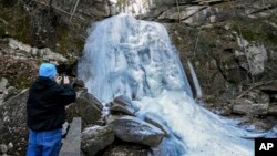 Bill Abee of Morganton, N.C., photographs a frozen High Shoals Falls at South Mountains State Park, Jan. 5, 2018, in Connelly Springs, N.C. The 60 foot waterfall is frozen as a result of below freezing temperatures.