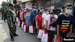 Sejumlah warga antre untuk menerima bantuan dari Presiden Joko Widodo di tengah penerapan PPKM di Jakarta, Jumat, 16 Juli 2021.