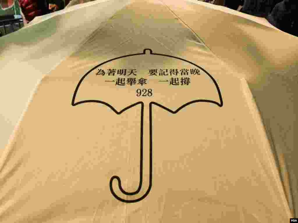 有香港市民撑着印有雨伞运动标志的黄色雨伞,参加平安夜游行