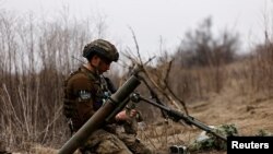 Seorang tentara Ukraina tengah menunggu aba-aba untuk menembakkan mortar di garis depan pertempuran di dekat wilayah Bakhmut, Ukraina, pada 16 Maret 2023. (Foto: Reuters/Violeta Santos Moura)
