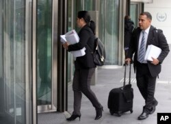 Members of the team of ousted Venezuelan prosecutor general Luisa Ortega carry evidence into the International Criminal Court denouncing President Maduro for crimes against humanity, in The Hague, Netherlands, Nov. 16, 2017.