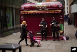 Police officers stand guard in central Manchester, Britain, May 24, 2017 after Monday's suicide attack at an Ariana Grande concert.