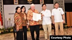 CEO Freeport-McMoran Richard Adkerson (tengah) dan Direktur Utama PT Inalum Budi G Sadikin menunjukkan dokumen usai penandatanganan Sales Puchase Agreement di Jakarta, Kamis sore (27/9). (Foto: courtesy)