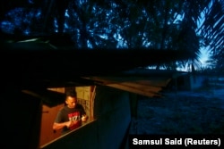 Pekerja asal Indonesia Abdul Rahim Gani, 32, memotong buah di rumahnya dekat perkebunan kelapa sawit di Felda Bukit Cerakah di distrik Klang, di luar Kuala Lumpur, 16 April 2014. (Foto: REUTERS/Samsul Said)
