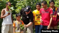Indonesian villagers in a kratom-growing area hold some of the leaves. (Credit: C. Kratom)