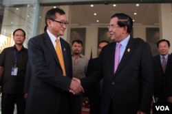 រូបឯកសារ៖ លោក​នាយក​រដ្ឋ​មន្រ្តី​ហ៊ុន​ សែន​ និង​លោក​សម​ រង្សី​ ប្រធាន​គណបក្ស​សង្គ្រោះ​ជាតិ​ ចាប់​ដៃ​គ្នា​នៅ​មុខរដ្ឋសភាជាតិ​ បន្ទាប់​ពី​ការ​បោះឆ្នោត​ផ្តល់​សេចក្តី​ទុក​ចិត្ត​គណៈកម្មាធិការ​ជាតិ​រៀបចំ​ការបោះឆ្នោត ​រាជធានី​ភ្នំពេញ​ ថ្ងៃ​ទី​៩​ ខែ​មេសា​ ឆ្នាំ​២០១៥។ (នូវ​ ពៅ​លក្ខិណា/VOA)