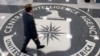 FILE - A man crosses the Central Intelligence Agency logo in the lobby of CIA Headquarters in Langley, Virginia.