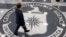 FILE - A man crosses the Central Intelligence Agency logo in the lobby of CIA Headquarters in Langley, Virginia.