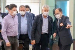 FILE - French senator Alain Richard, second right, is escorted by a Taiwanese official upon arrival at Taoyuan International Airport in Taiwan, Oct. 6, 2021. Richard led a group of French senators to Taiwan for a five-day visit.