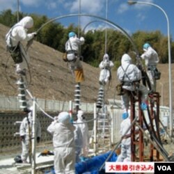 Para pekerja Jepang berusaha memperbaiki jaringan listrik pada PLTN Fukushima, Kamis (24/3).
