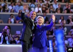 President Barack Obama and Democratic Presidential candidate Hillary Clinton wave together during the third day of the Democratic National Convention in Philadelphia , July 27, 2016.